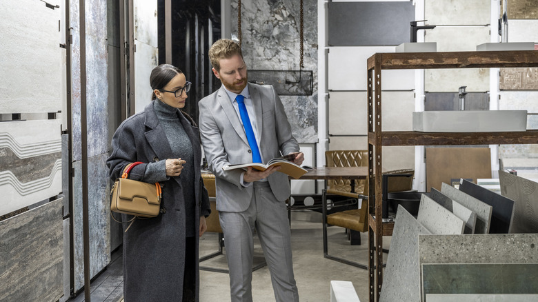 A man showing a woman kitchen countertop options.