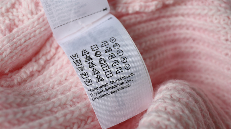 A care label on a pink woolen clothing item