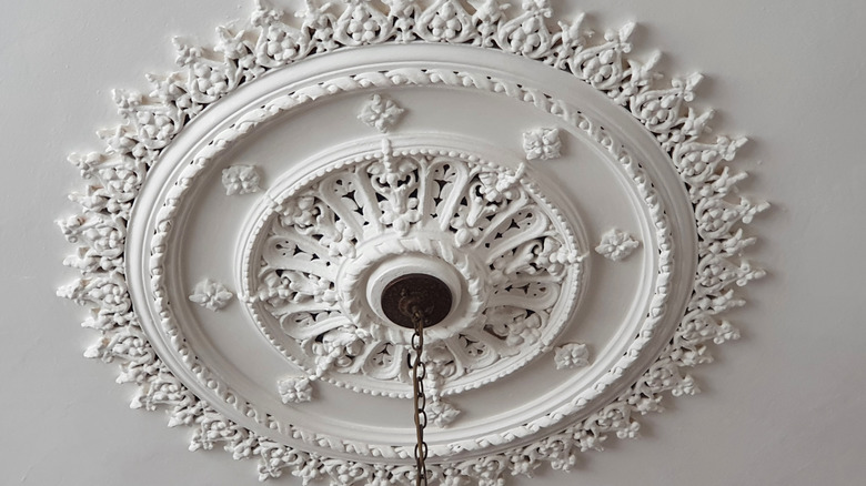 White ceiling rose with light fixture hanging from it