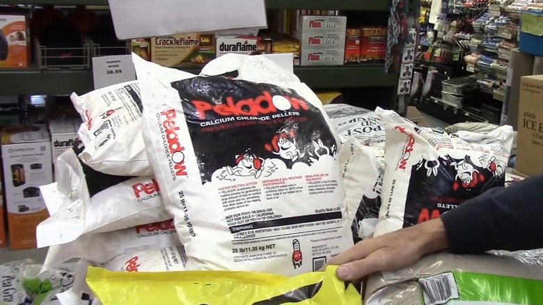 Hand beside a bag of calcium chloride pellets in a store