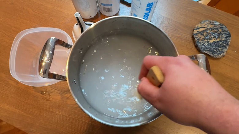 Hand mixing salt and water for brine