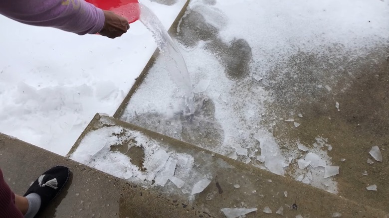 Pouring warm water, dish soap, and rubbing alcohol DIY ice melt on snow