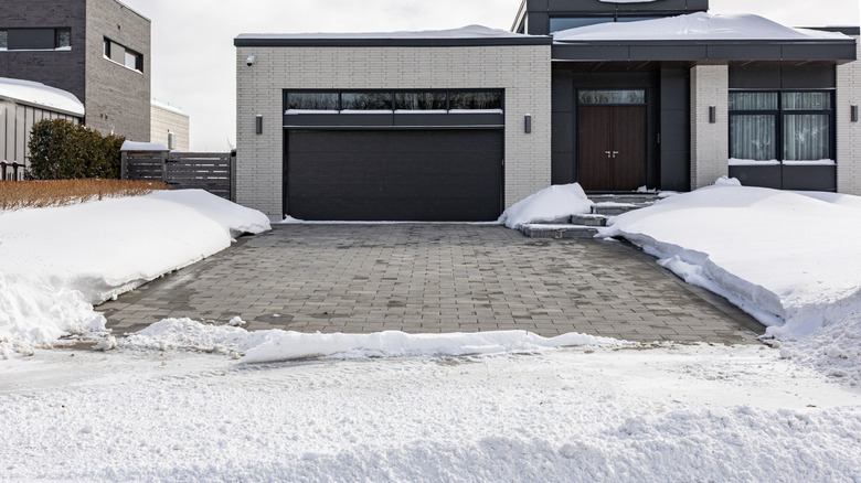 A heated driveway is snow-free while the regions near it are covered