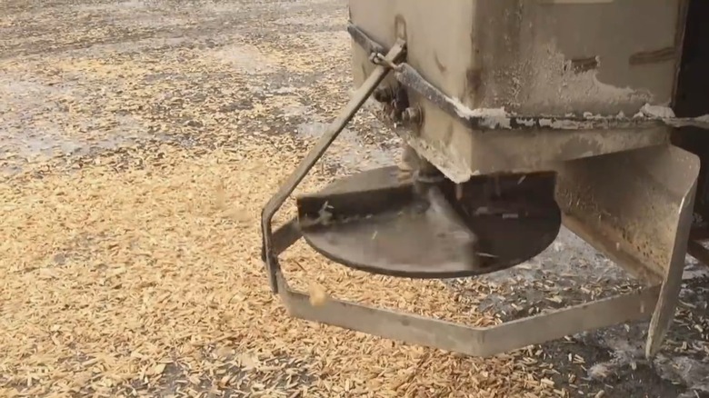 A city truck spreading wood chips on an icy road