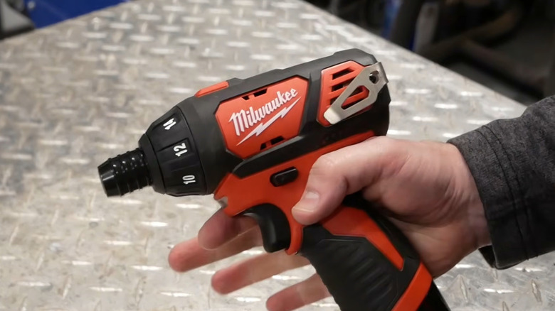 A person holding a Milwaukee drill