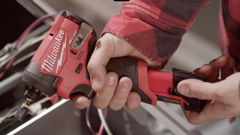 A person holding Milwaukee's M12 Lithium-Ion Brushless Cordless ¼-inch Hex Impact Driver