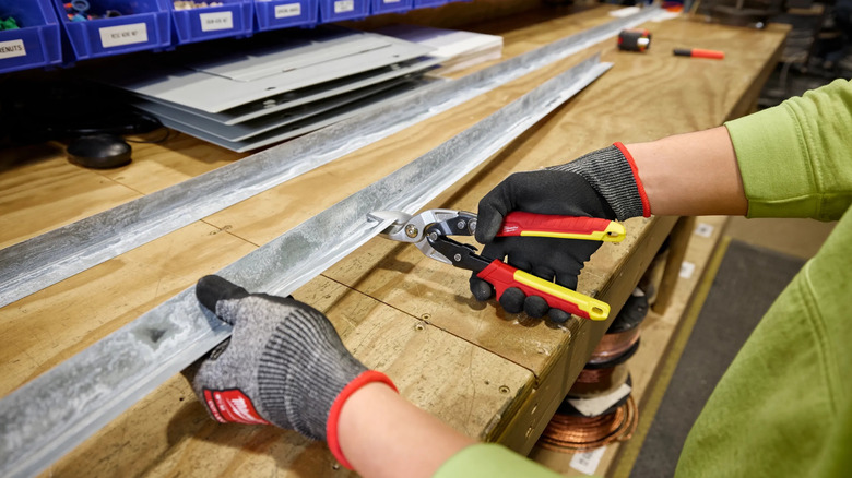 A person cutting metal with Milwaukee's 10-inch Straight-Cut Aviation Snips