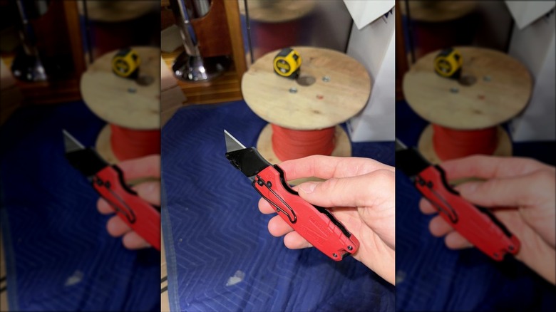 A person holding a Milwaukee utility knife