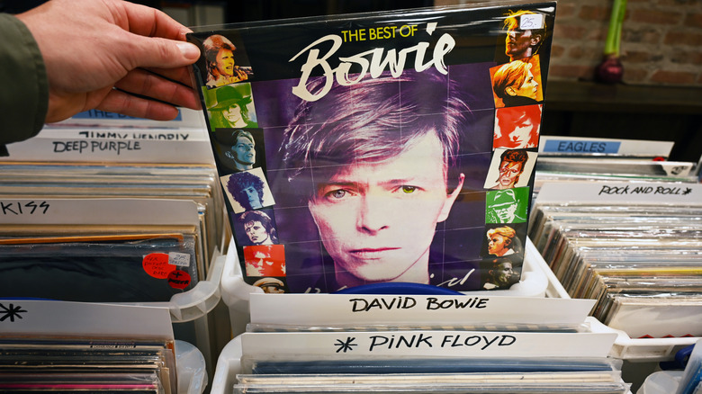 Closeup of a man's hand pulling a David Bowie album from a stack