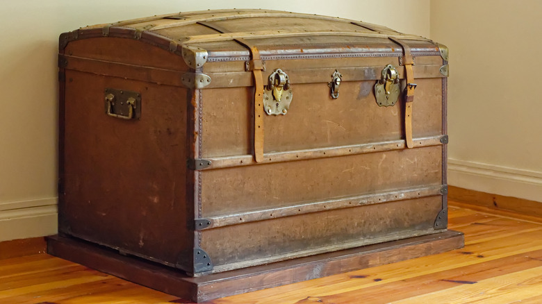 Vintage wooden steamer trunk next to a wall