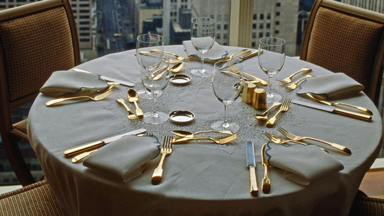 A round table set with gold flatware