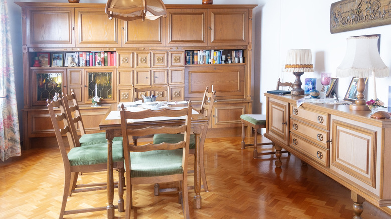 An '80s dining room with a massive wood cabinet, dining table, and buffet