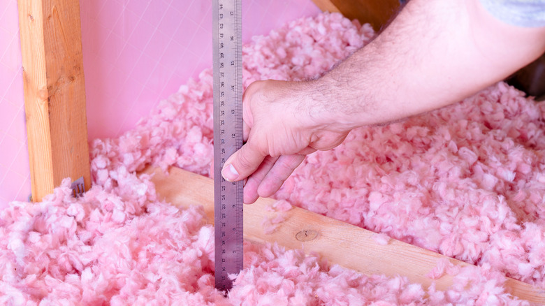 Close up of person measuring insulation level