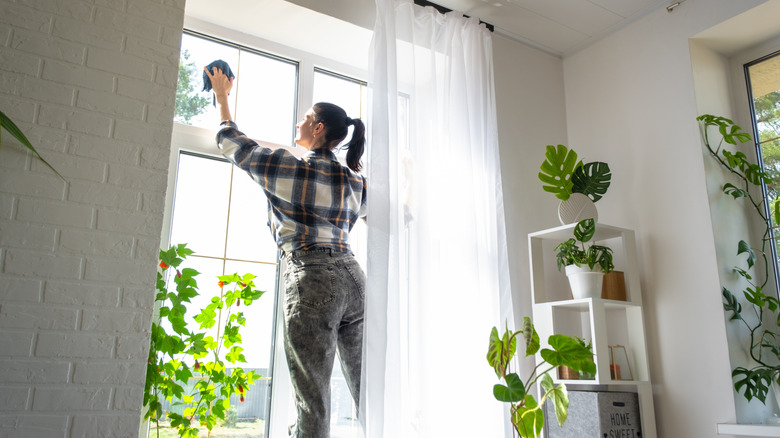 Person cleaning windows in white home