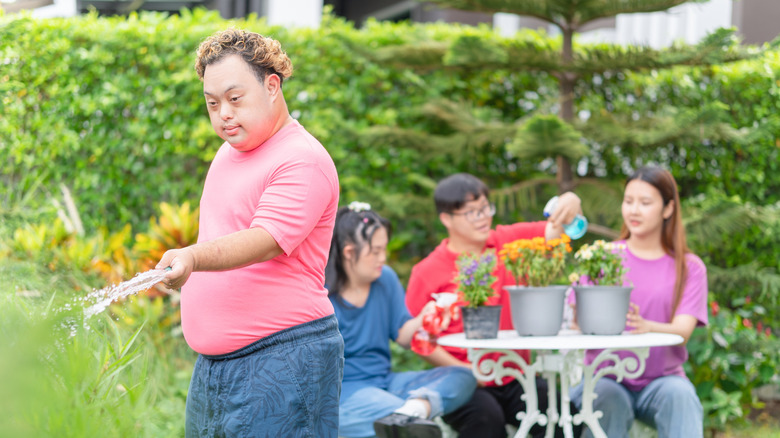 Group of people watering and planting flowers