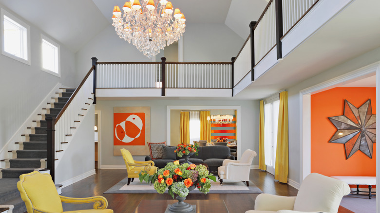 Living room with statement chandelier and bright-colored furntiture