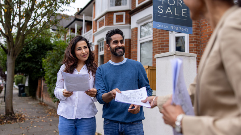 People talking to a real estate agent about a property