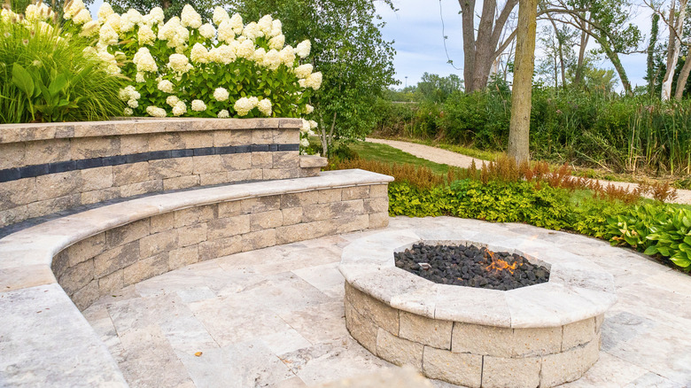 Patio and firepit sounded by borders and plants