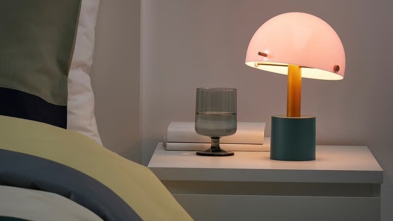 A small, tri-color retro lamp on a bedside table.