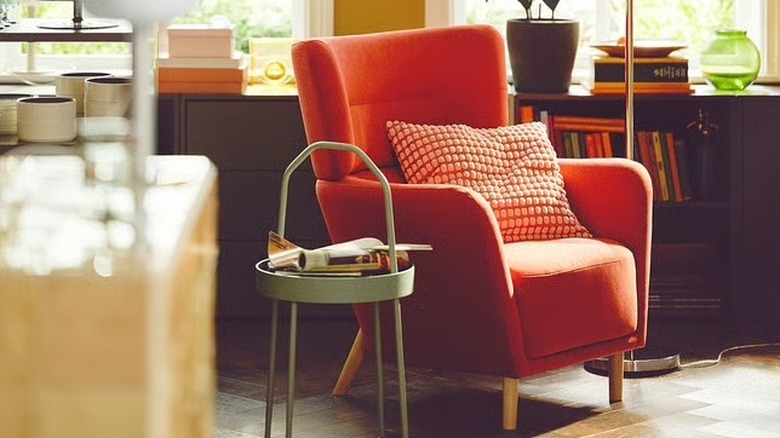A red wingback chair surrounded by modern furniture.