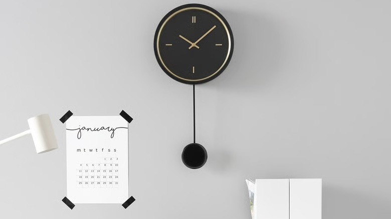 A modern black clock in a minimalist office.