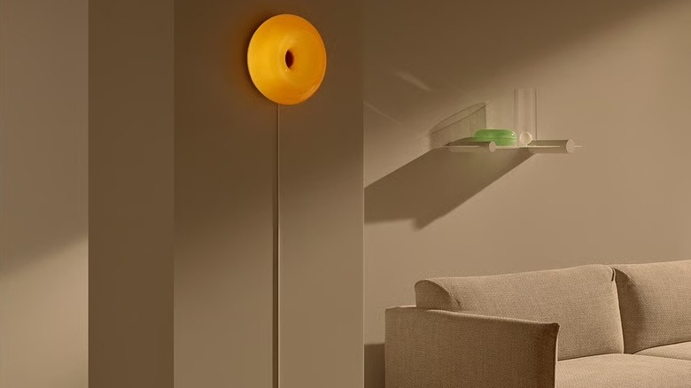 A retro orange wall lamp in an all beige room.