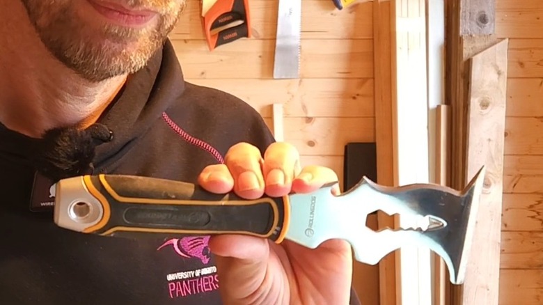 Man holding a multi-purpose painter's tool