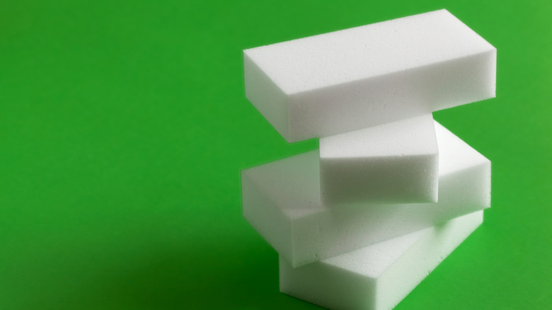 A stack of melamine sponges is shown against a green backdrop