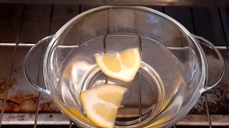 Lemons in a glass bowl are steaming in a dirty oven