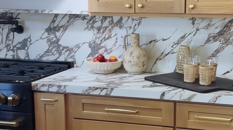 A porcelain backsplash that matches the counter with kitchen items on display on the countertop