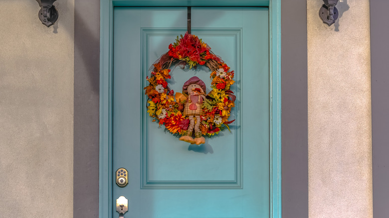 A kitschy turkey wreath hanging on a front door