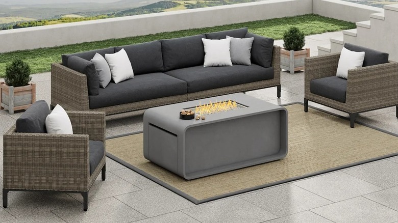 A seating set arranged around a fire table on a spacious patio