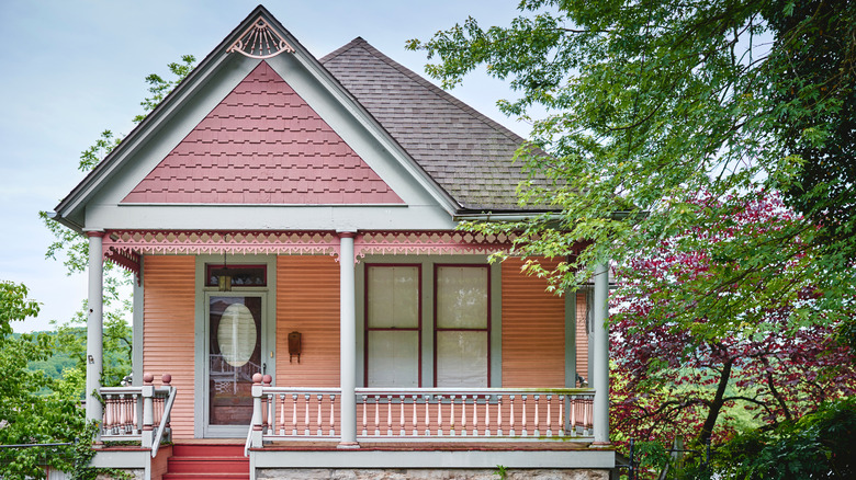 A pink and white one story Victorian house