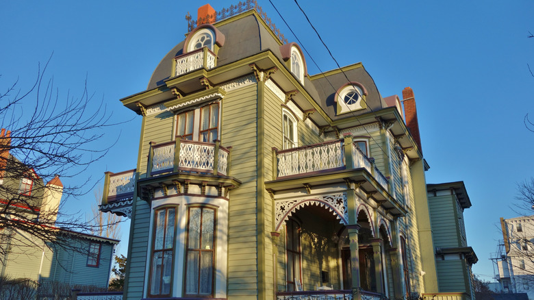 An avocado green colored historical home with brown and cream trim