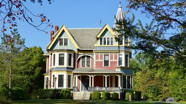 A multicolored Victorian home in shades of mauve, light blue, yellow, and gray