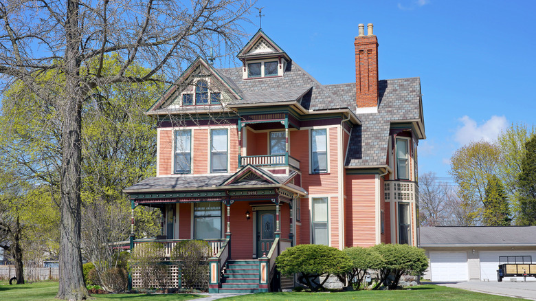 A salmon hued Victorian home with colorful architectural details