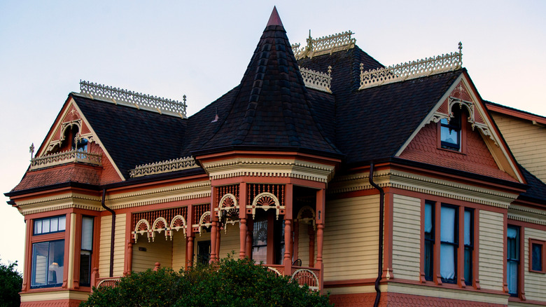 Victorian home painted in mustard yellow and terracotta with black accents