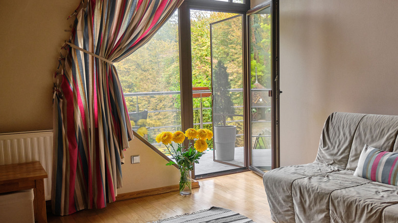 Striped curtains tied back around door from living area to patio