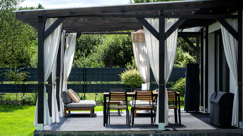 Sheer curtains around a covered structure on a patio
