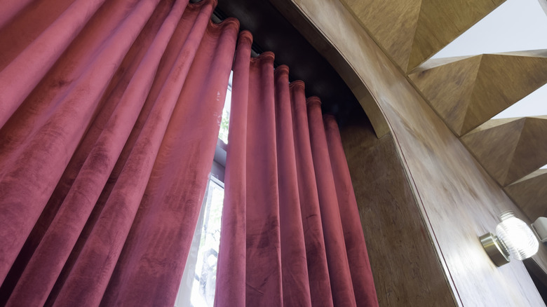 Velvet maroon curtain hanging from a rod