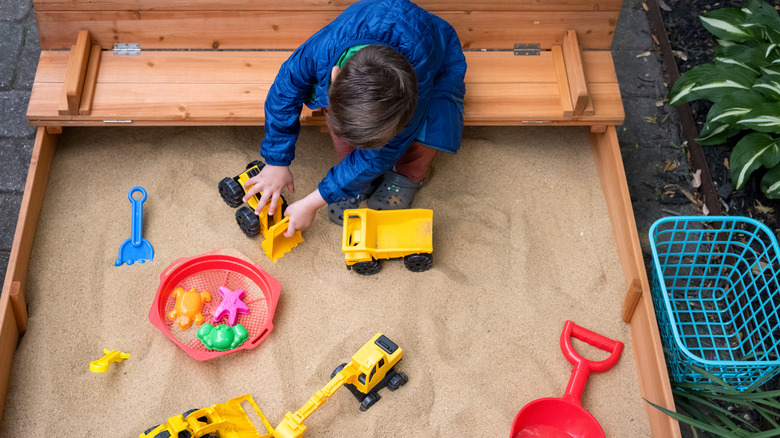 A kid playing in a sandbox.