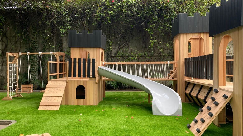 A large wooden playset in a backyard