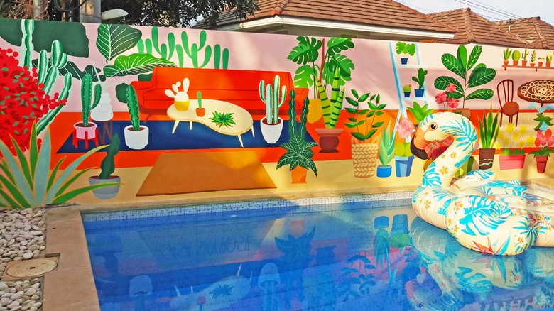 A swimming pool with a bold-colored and extensive mural.