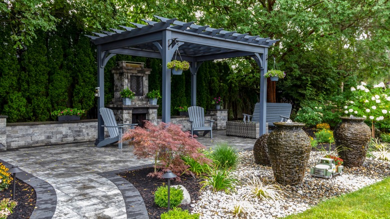 A backyard pergola with stone walkway
