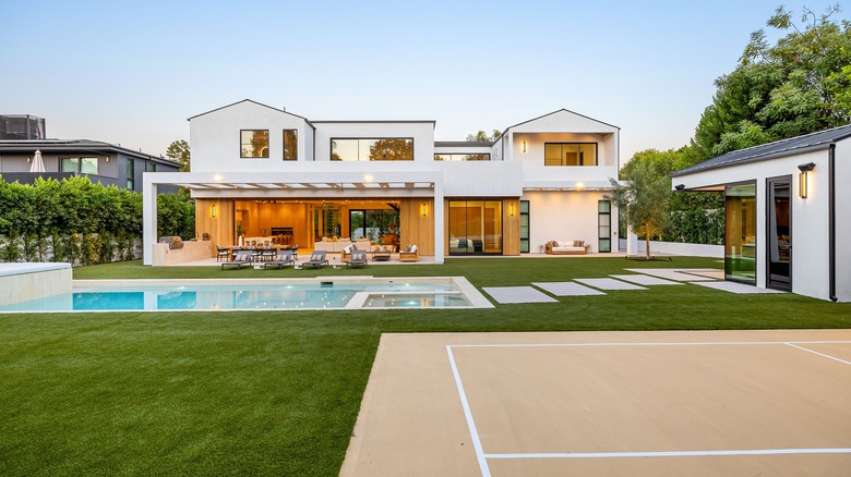 A large backyard with a pool and tennis court