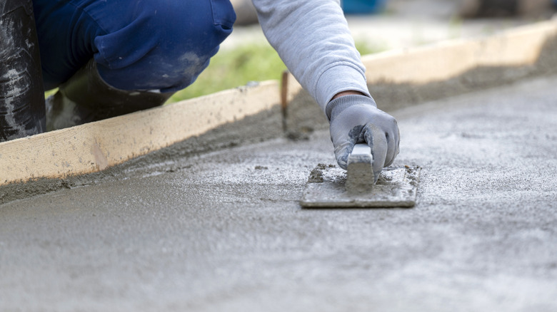 Close-up of a construction worker smoothing a concrete surface outdoors