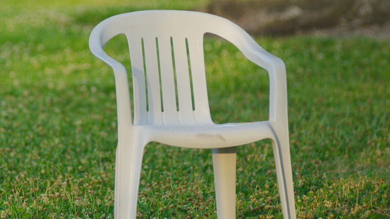 A white plastic chair on grassy lawn
