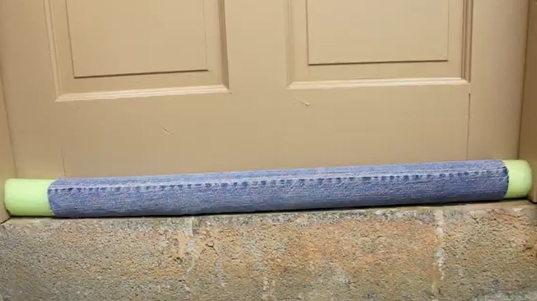 Pool noodle used at the base of a door to stop drafts