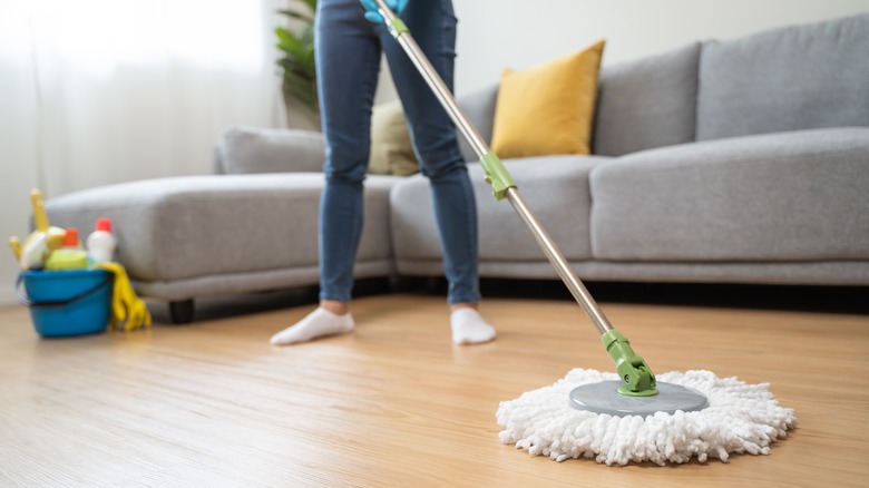 A woman mopping a wood floor.