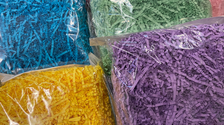 Decorative paper shred in different colors packaged inside plastic bags.